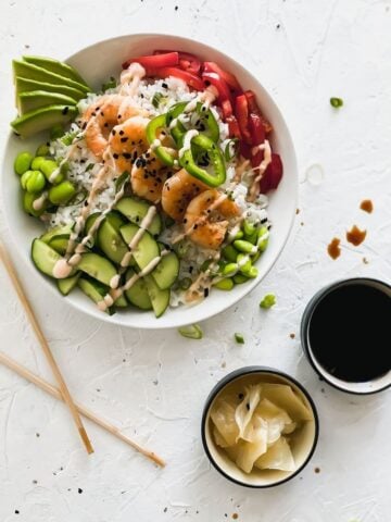 shrimp sushi bowl with chopsticks, sushi ginger, and soy sauce on the side