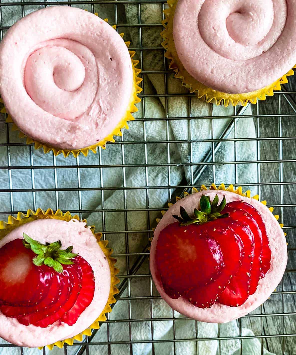 close up of almond cupcakes with strawberry buttercream frosting