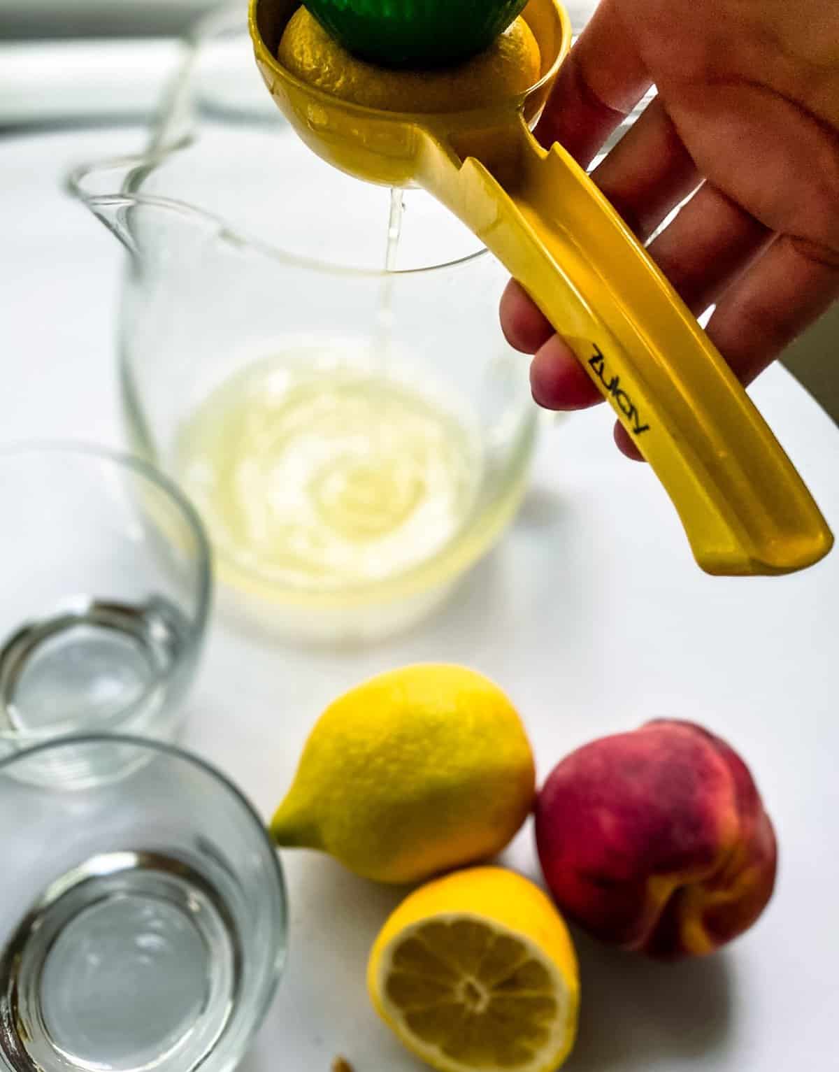 Squeezing lemon juice into a glass pitcher