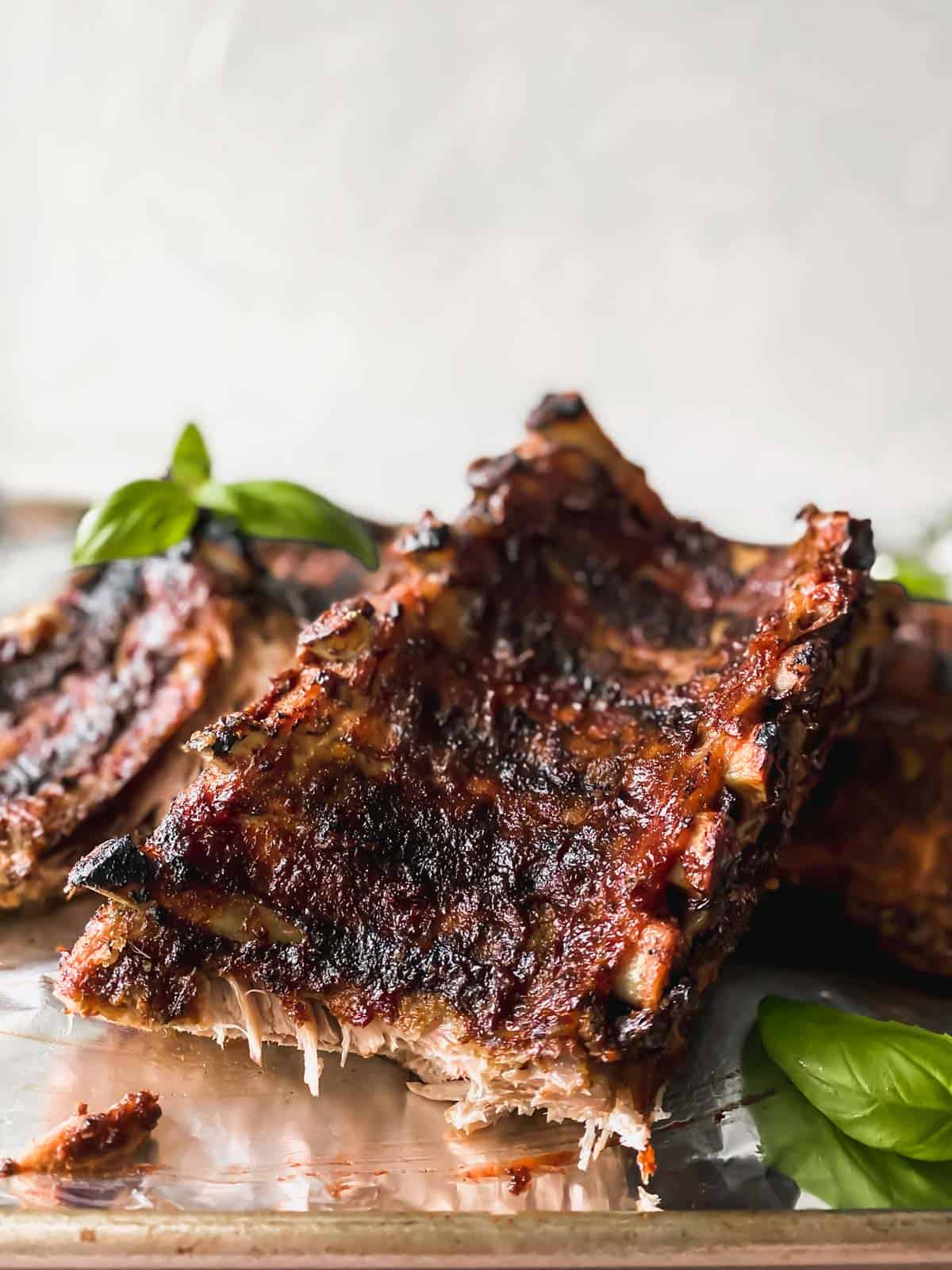 slab of bbq ribs with basil on a metal sheet pan