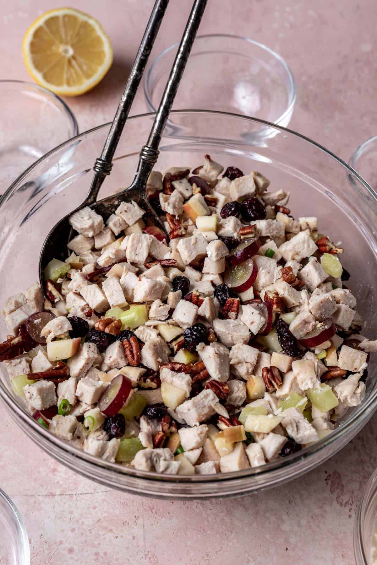 Chicken salad mixed together in a glass mixing bowl before adding the mayonnaise.