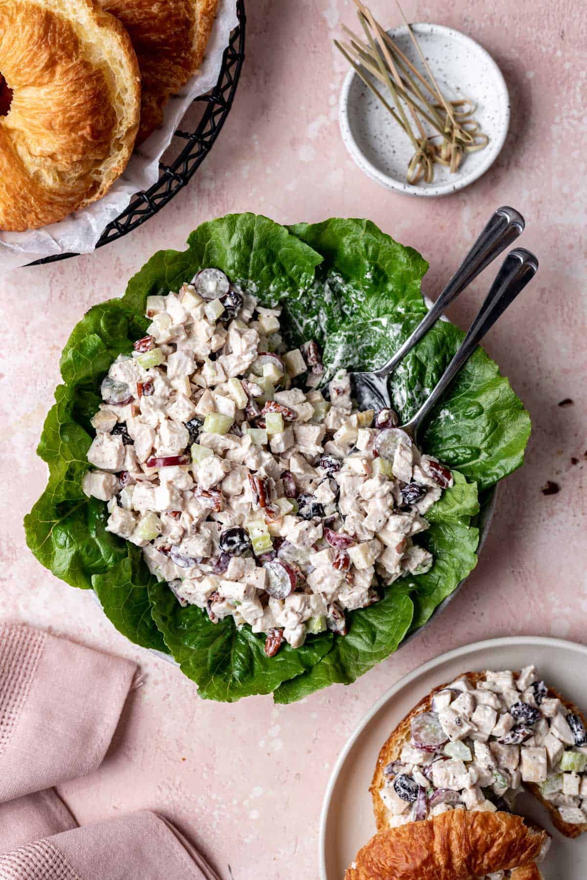 Cranberry pecan chicken salad on a serving plate with croissants off to the side.