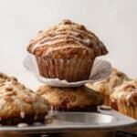Orange spice poppy seed muffins with a maple glaze stacked on top of each other.