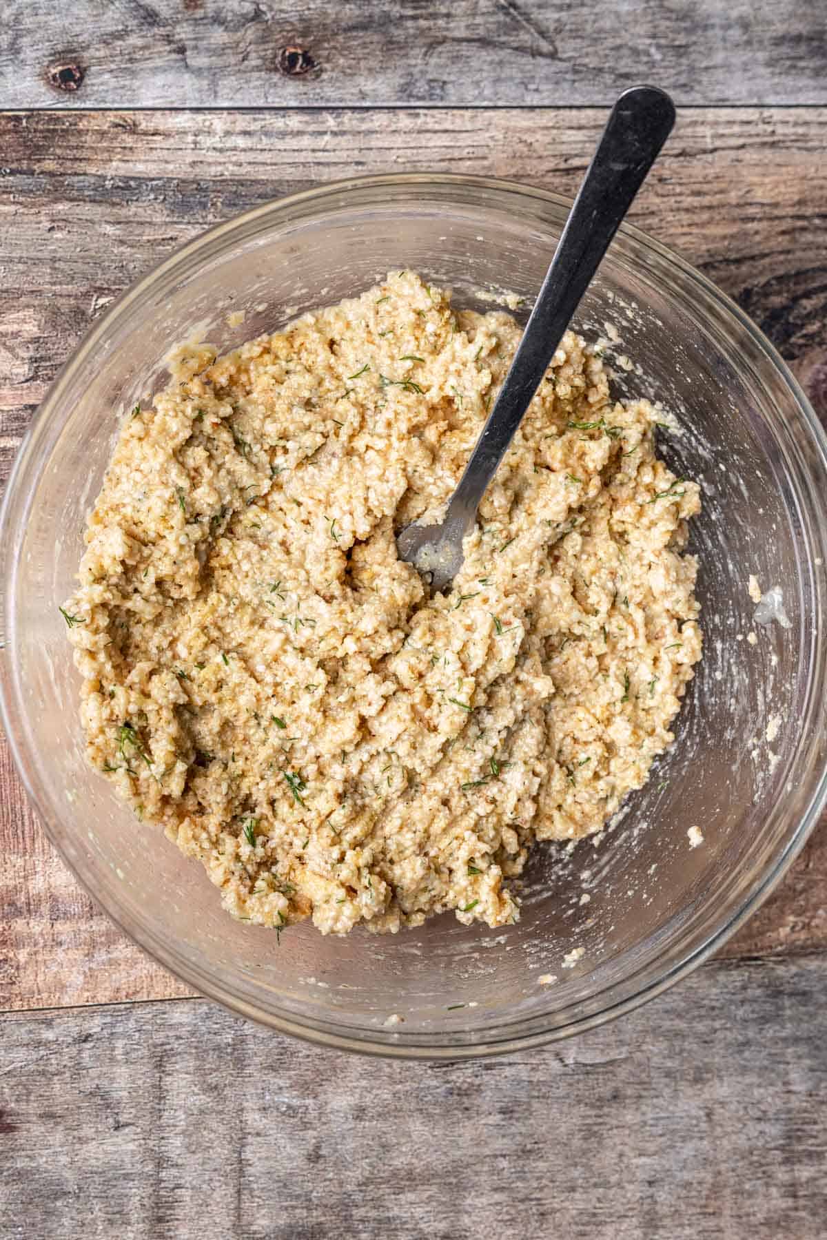 Matzo ball ingredients mixed together in a glass bowl.