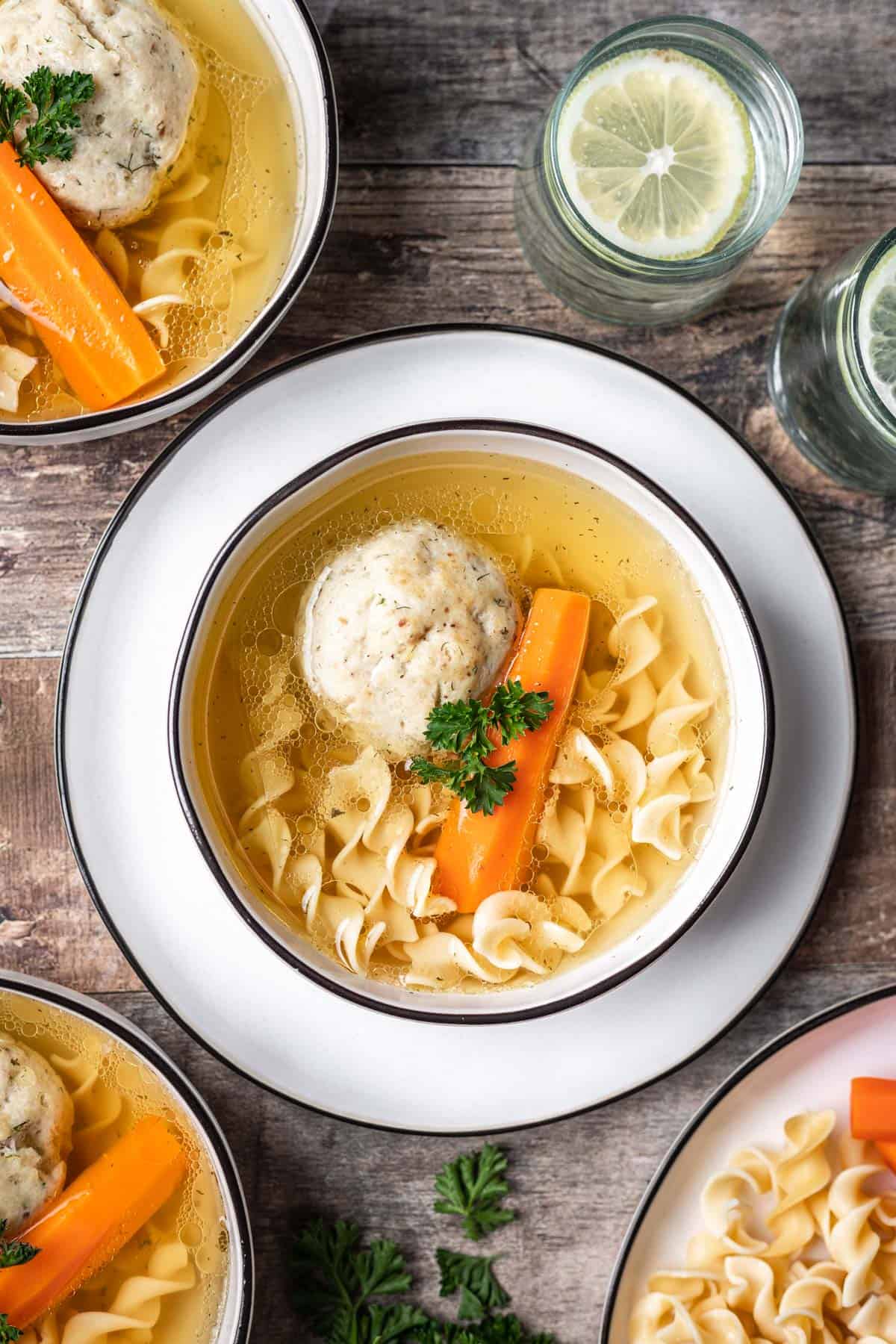 Instant pot matzo ball soup in a bowl with carrots and noodles.