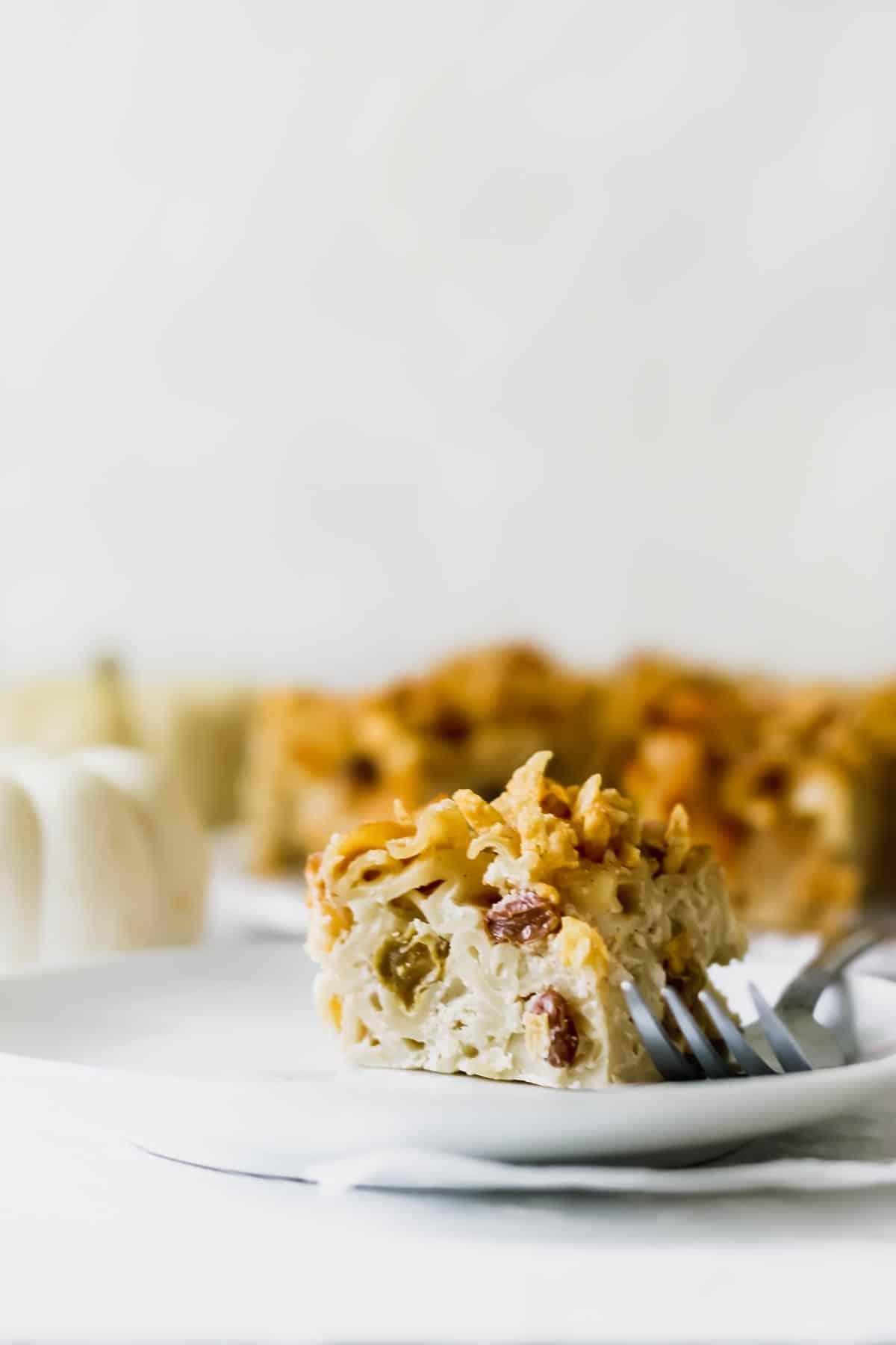 Up close view of a slice of kugel with a fork next to it.