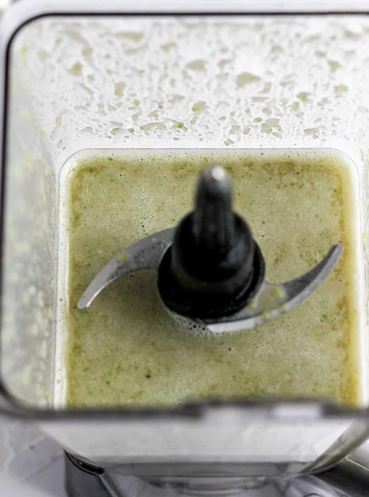 Blended jalapeños, beans, chiles, and broth in a blender.