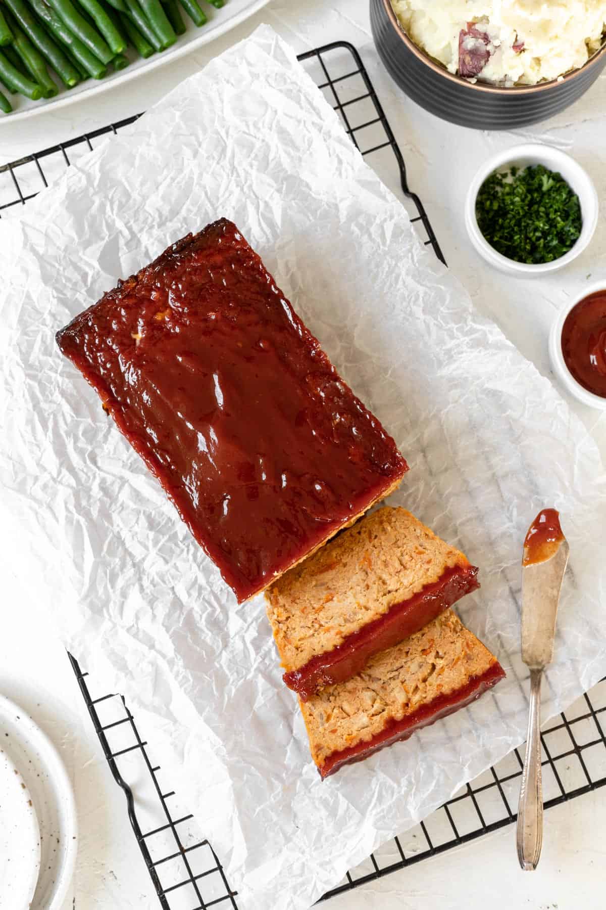 Sliced healthy chicken meatloaf on a cooling rack.