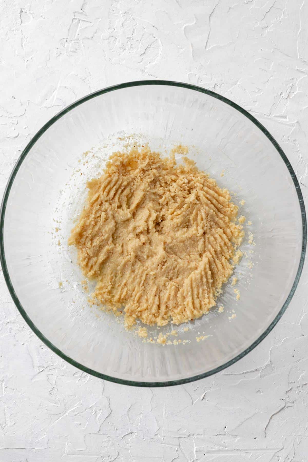 Breadcrumbs soaked in eggs and milk in a glass bowl.