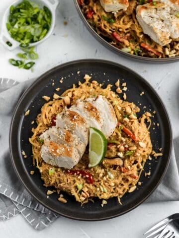 Thai peanut spaghetti squash on a dark gray plate with a gray napkin under.