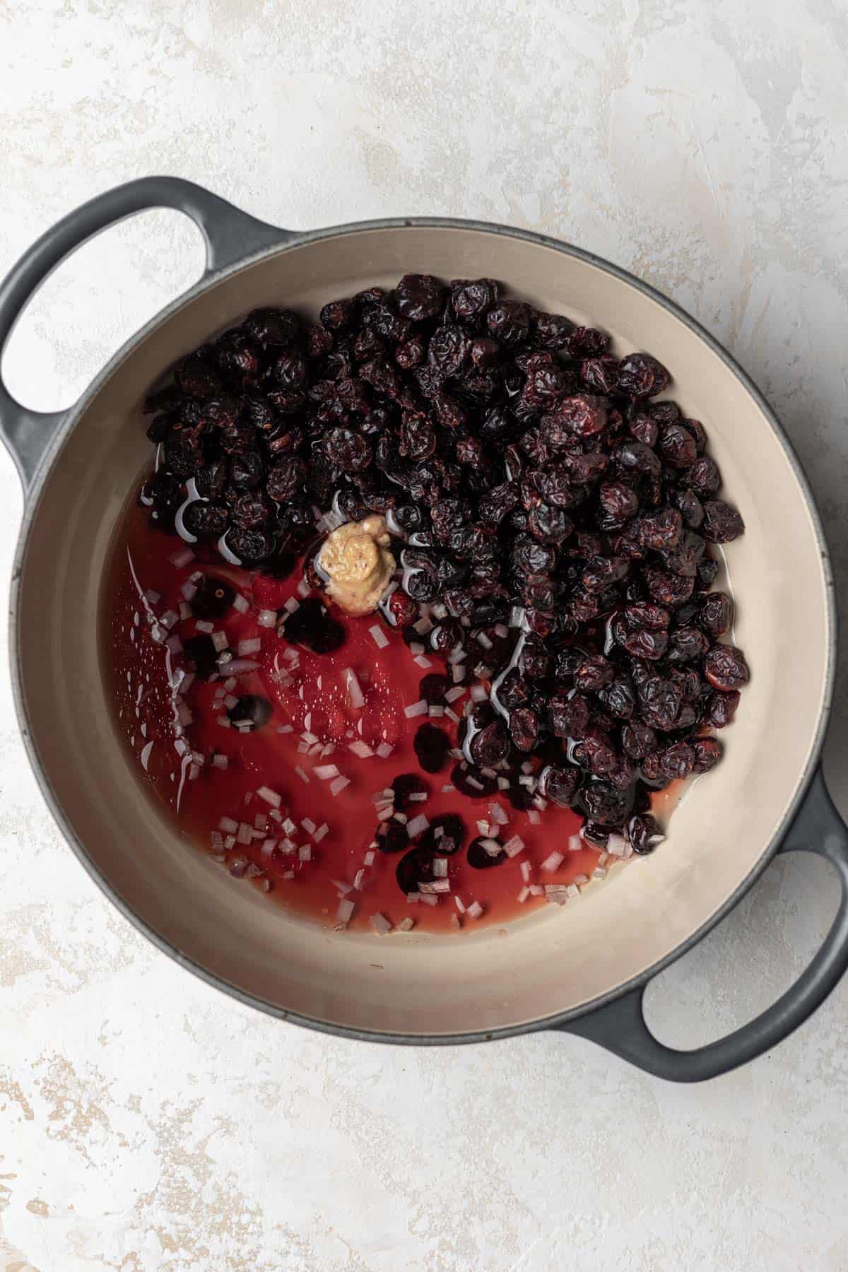 Dried cranberries, red wine vinegar, and dijon mustard in a large pot.