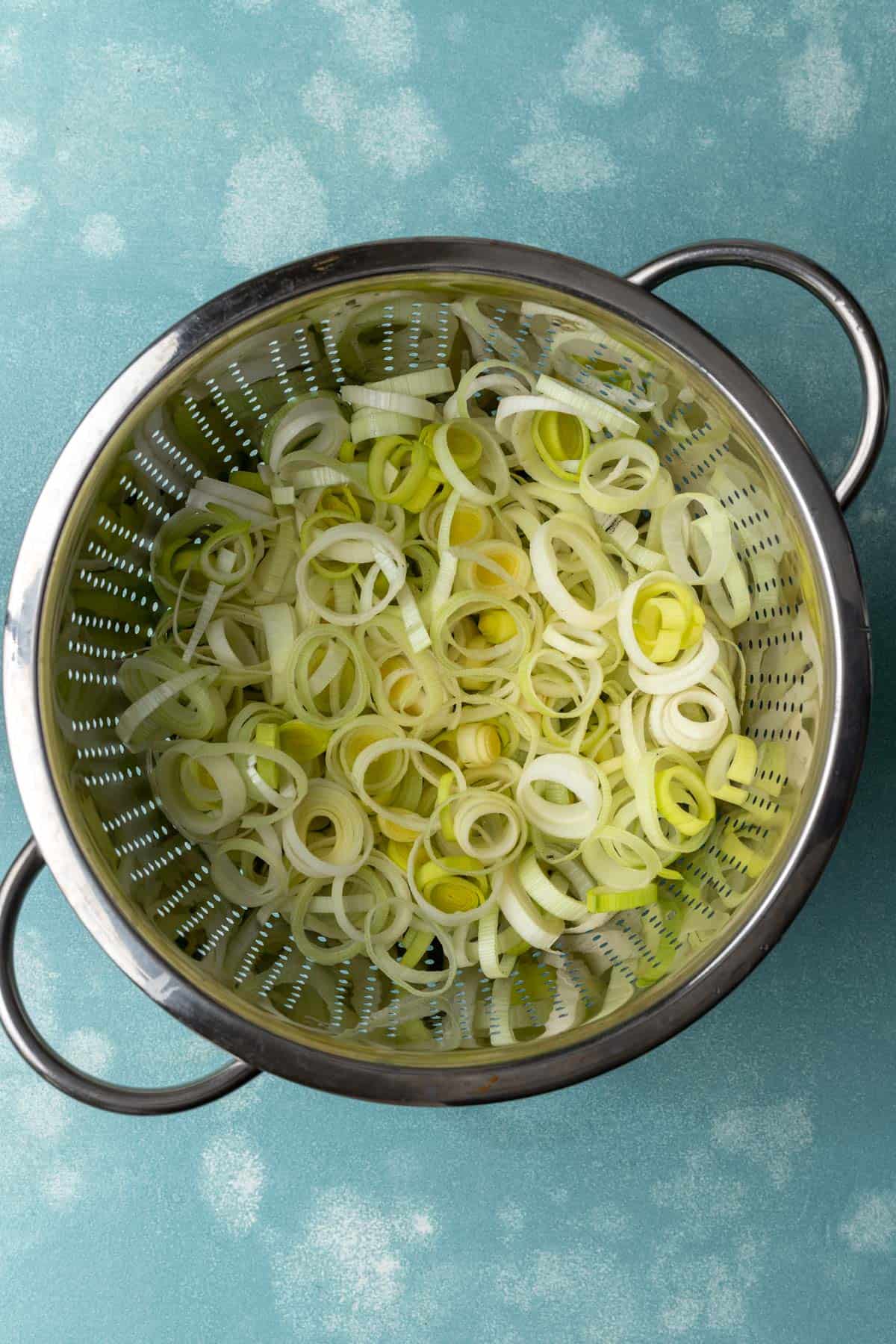 Separated leeks in a colander before washing.