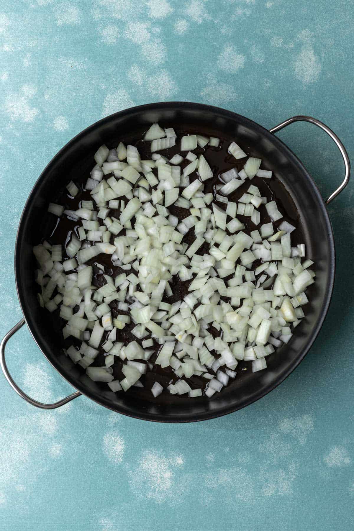 Raw onions in a large skillet before cooking.