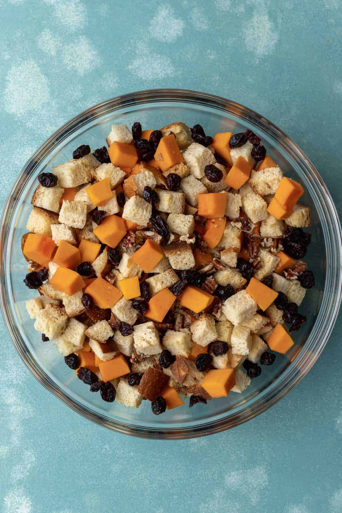 Combined challah, butternut squash, pecans, and dried cranberries in a bowl.