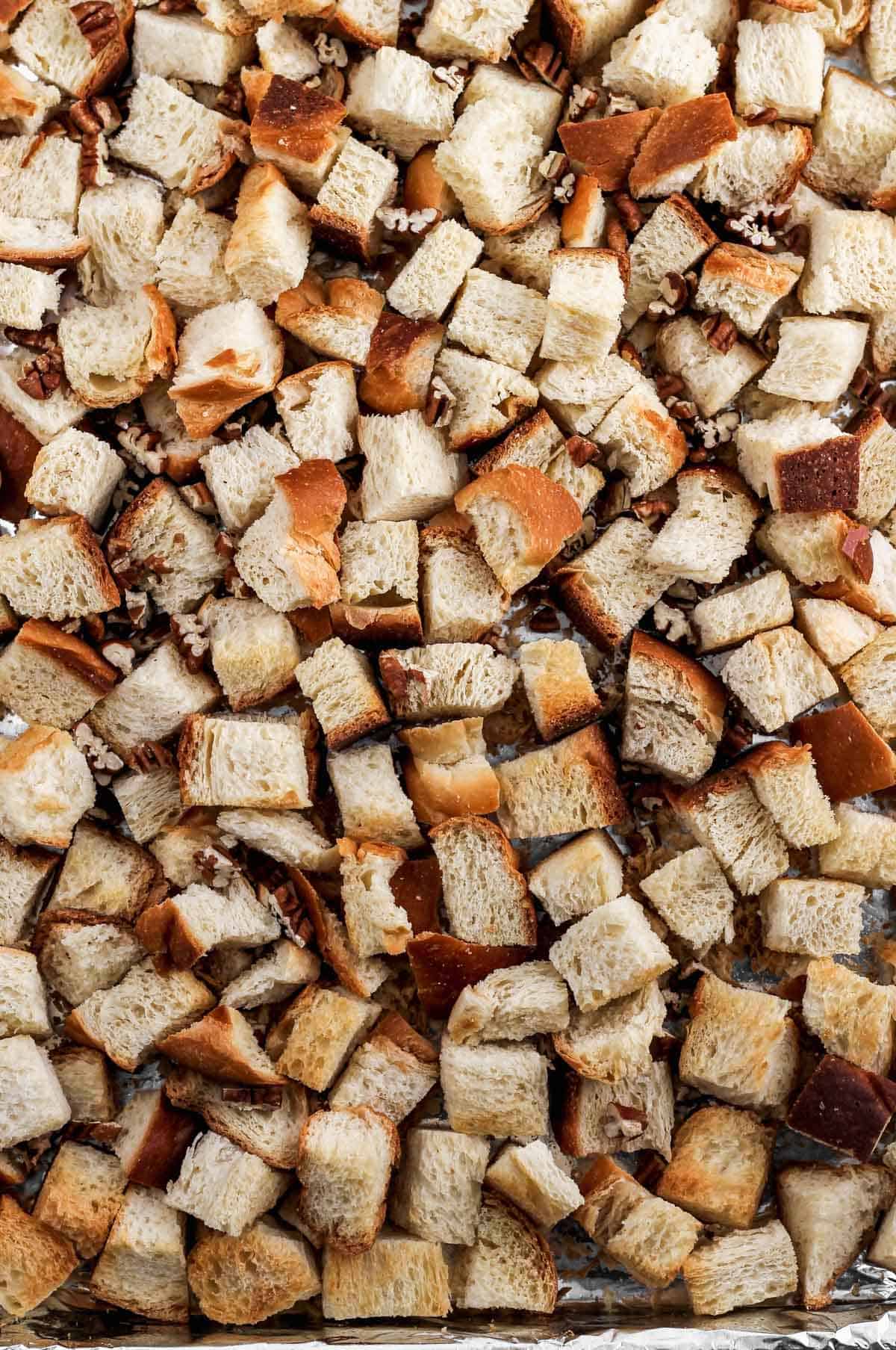 Cubed toasted challah on a sheet pan.