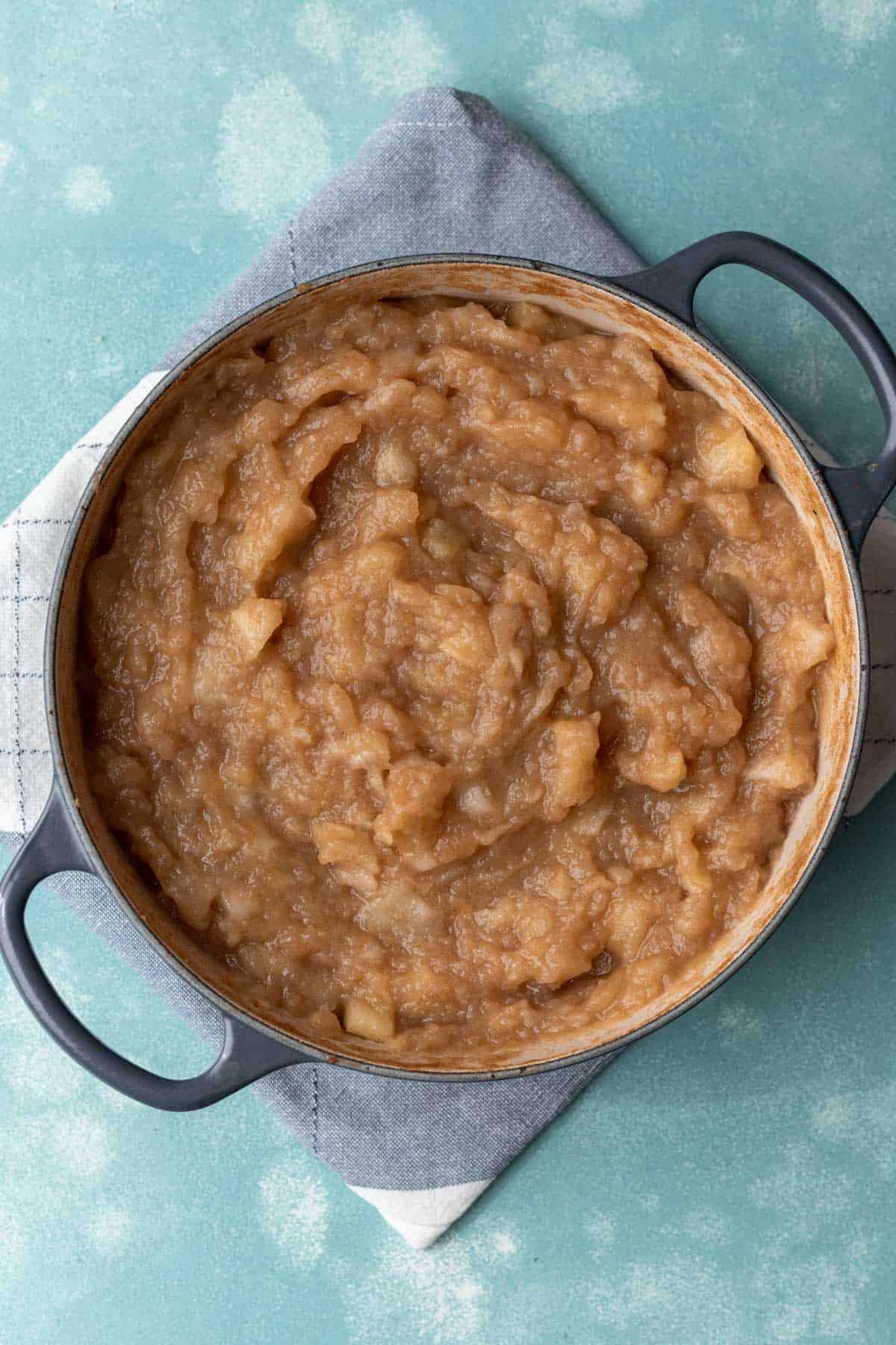 Cooked apples completely mashed and broken down in a large stock pot.