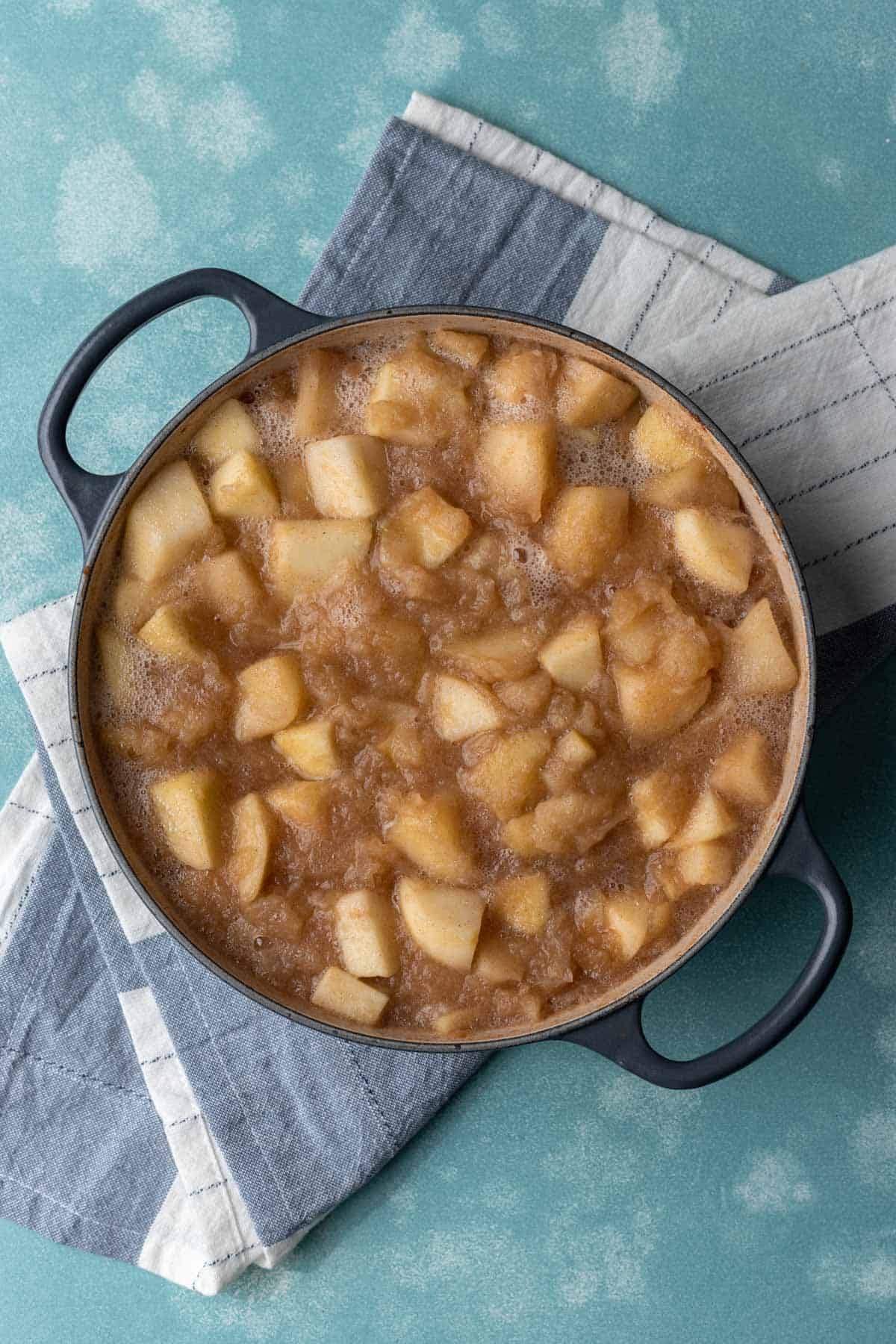 Cooked apples slightly broken down in a large stock pot.