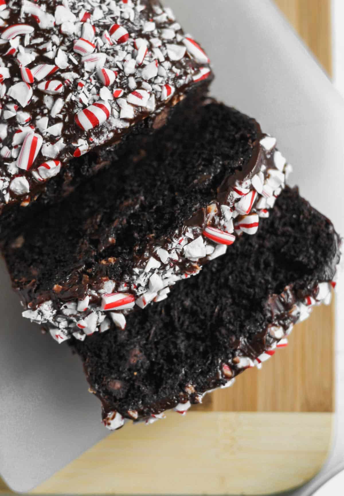 Close up image of peppermint death by chocolate zucchini bread with chocolate glaze and crushed peppermint topping.