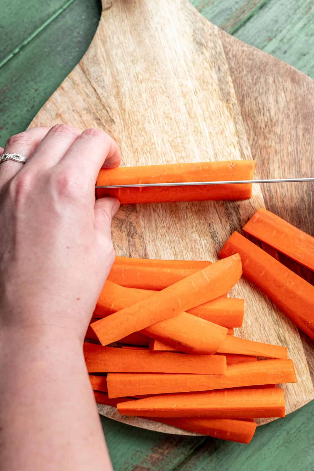 An overhead view of a carrot being cut into fries.