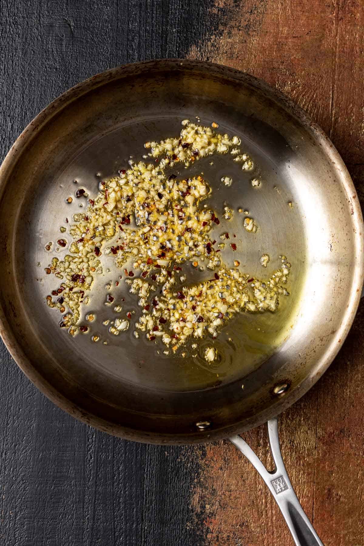 Toasted garlic, ginger, and red pepper flakes in a skillet.