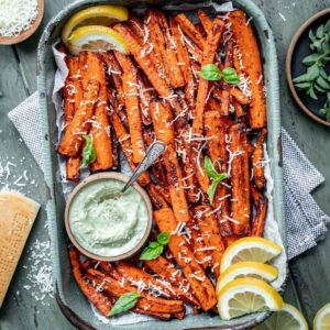 Air fryer carrot fries in a tray with a side of pesto aioli.