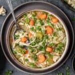 Instant pot chicken rice soup in a bowl with a spoon.