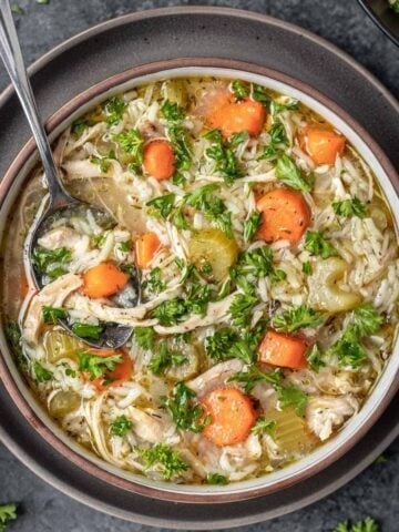 Instant pot chicken rice soup in a bowl with a spoon.