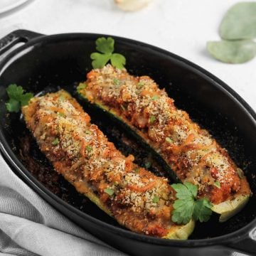 Italian zucchini garnished with parsley in a black baking dish.