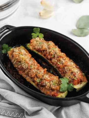 Italian zucchini garnished with parsley in a black baking dish.