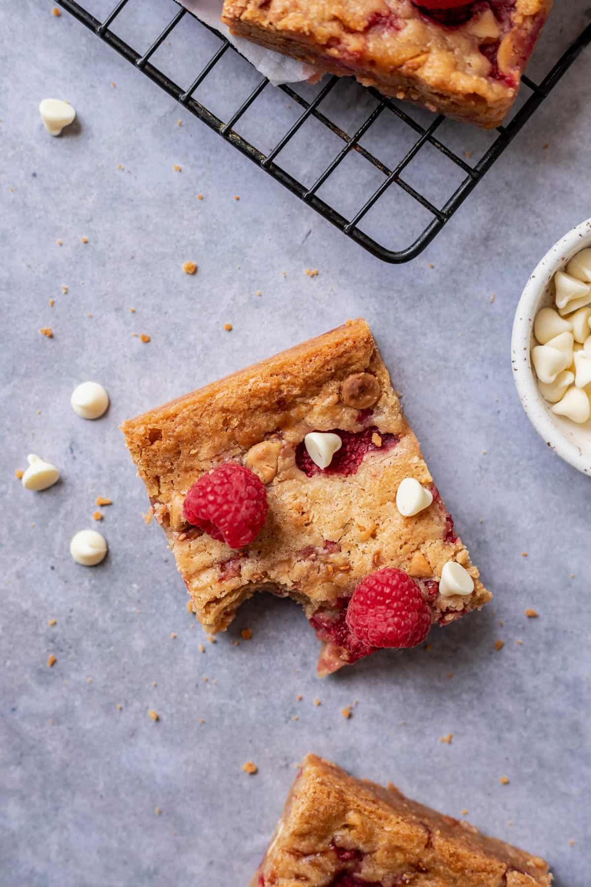 A white chocolate raspberry blondie with a bite taken out.