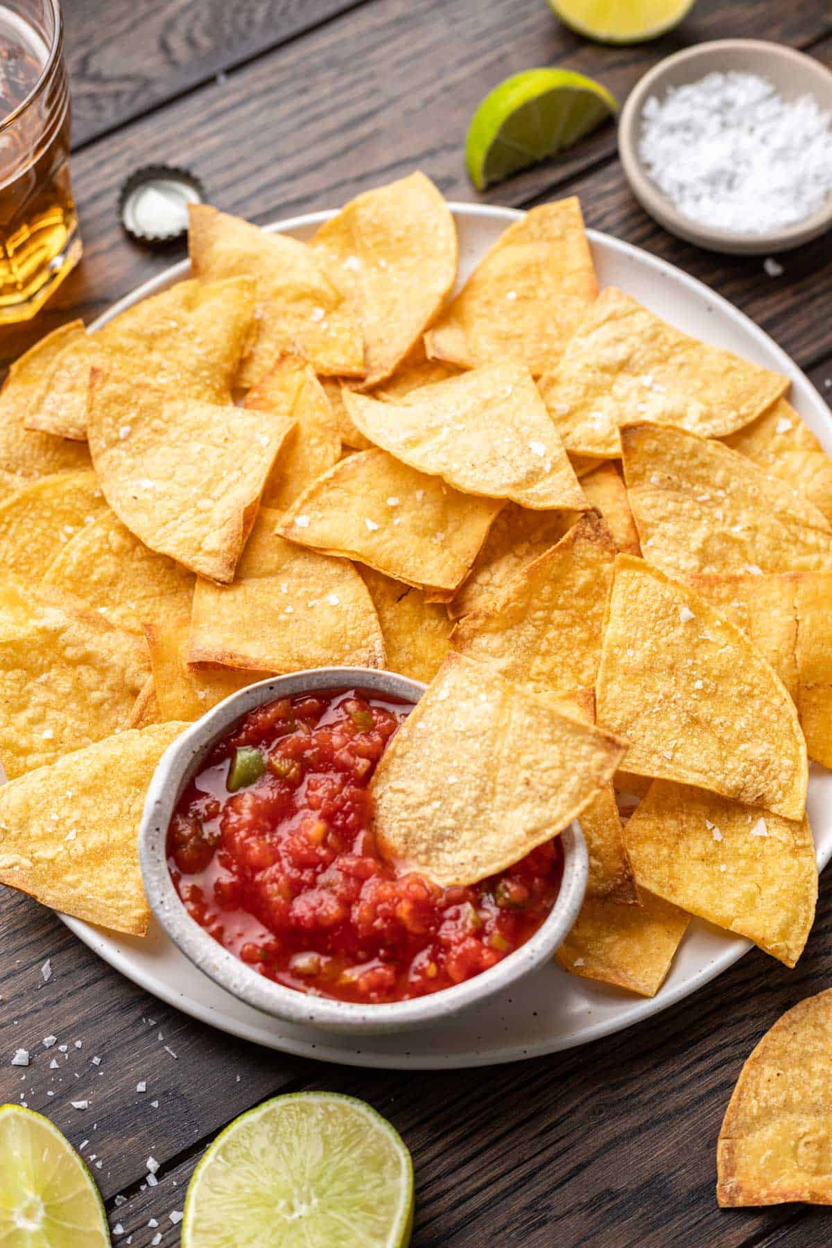 Air fryer tortilla chips on a serving platter with salsa.