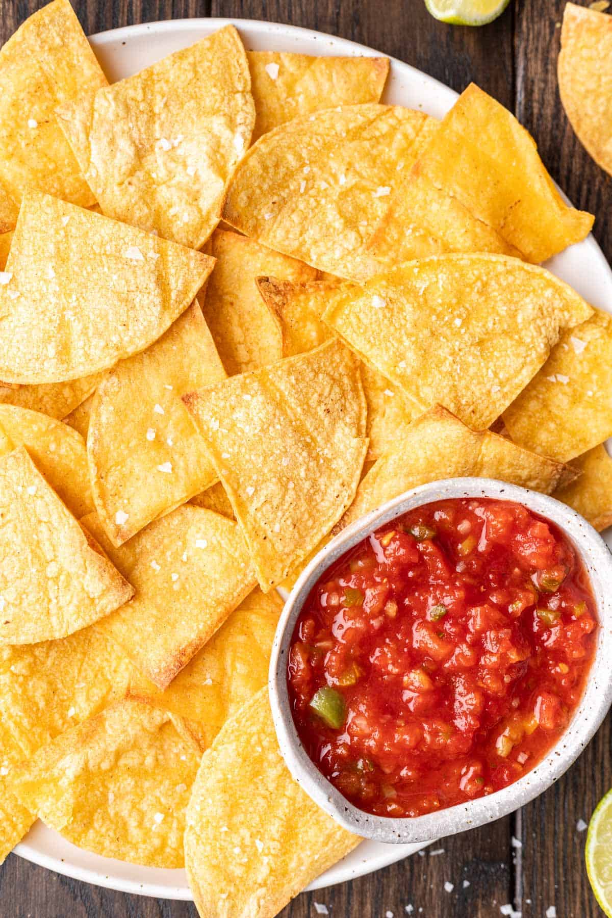 Air fryer tortilla chips stacked on each other on a serving platter.