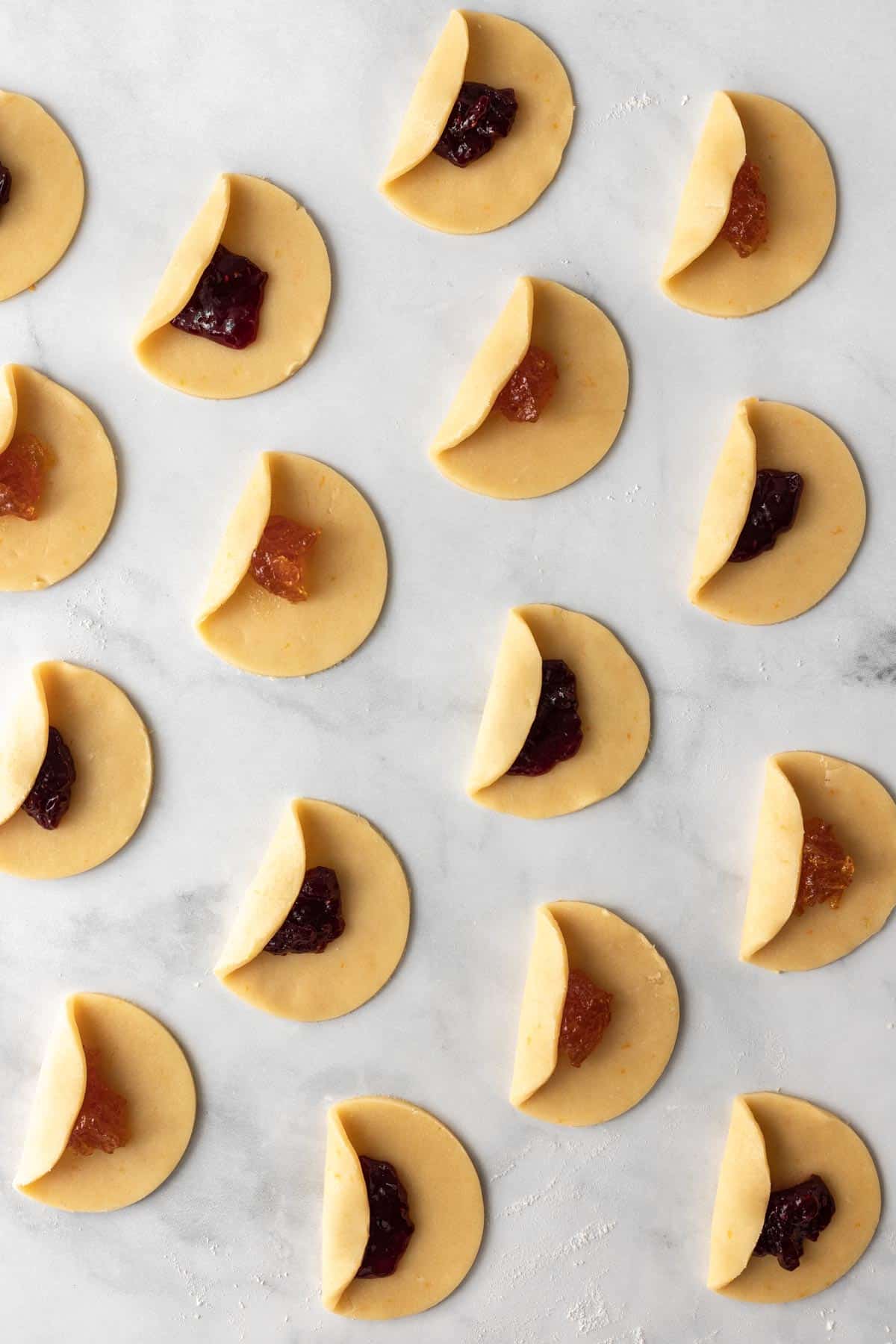 One side of the dough circles folded over the jam filling.