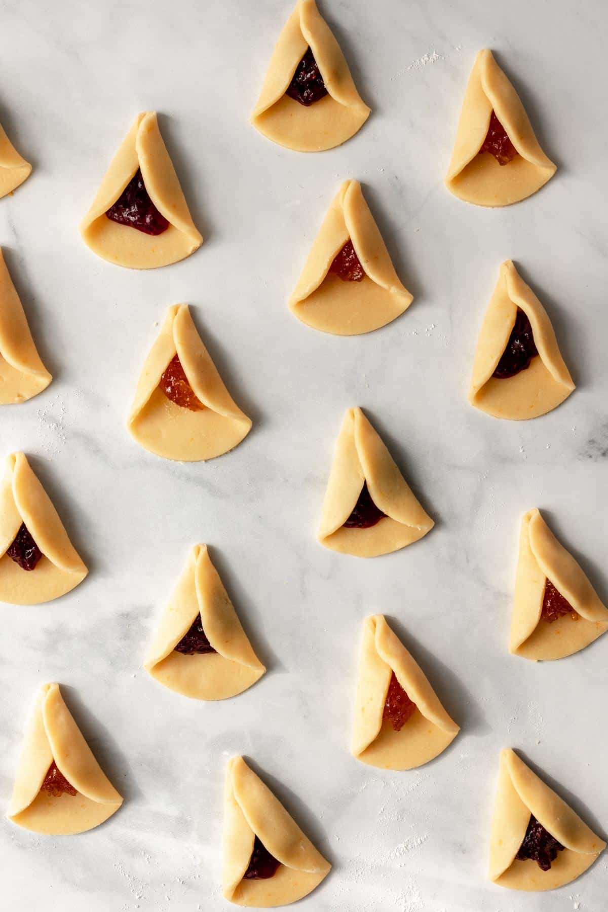 2 sides of the dough circles folded over the jam filling.