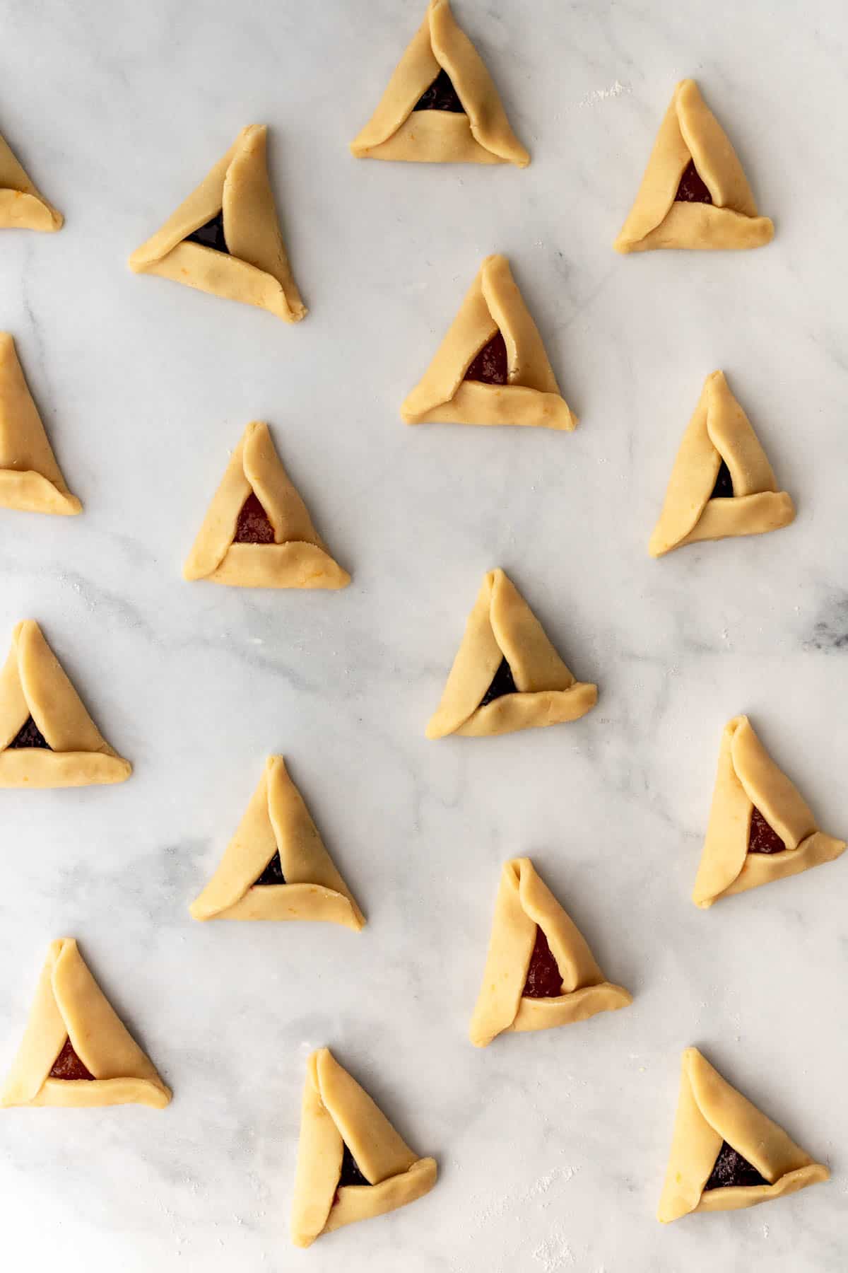 All sides of the dough circles folded over the jam filling to form a triangle.