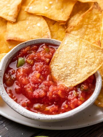 Air fryer tortilla chip dipped in salsa.