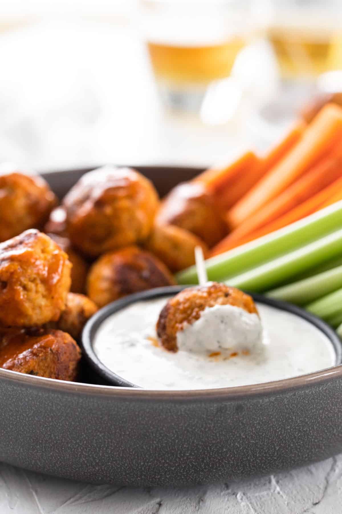 A buffalo turkey meatball on a toothpick dipped in feta ranch.