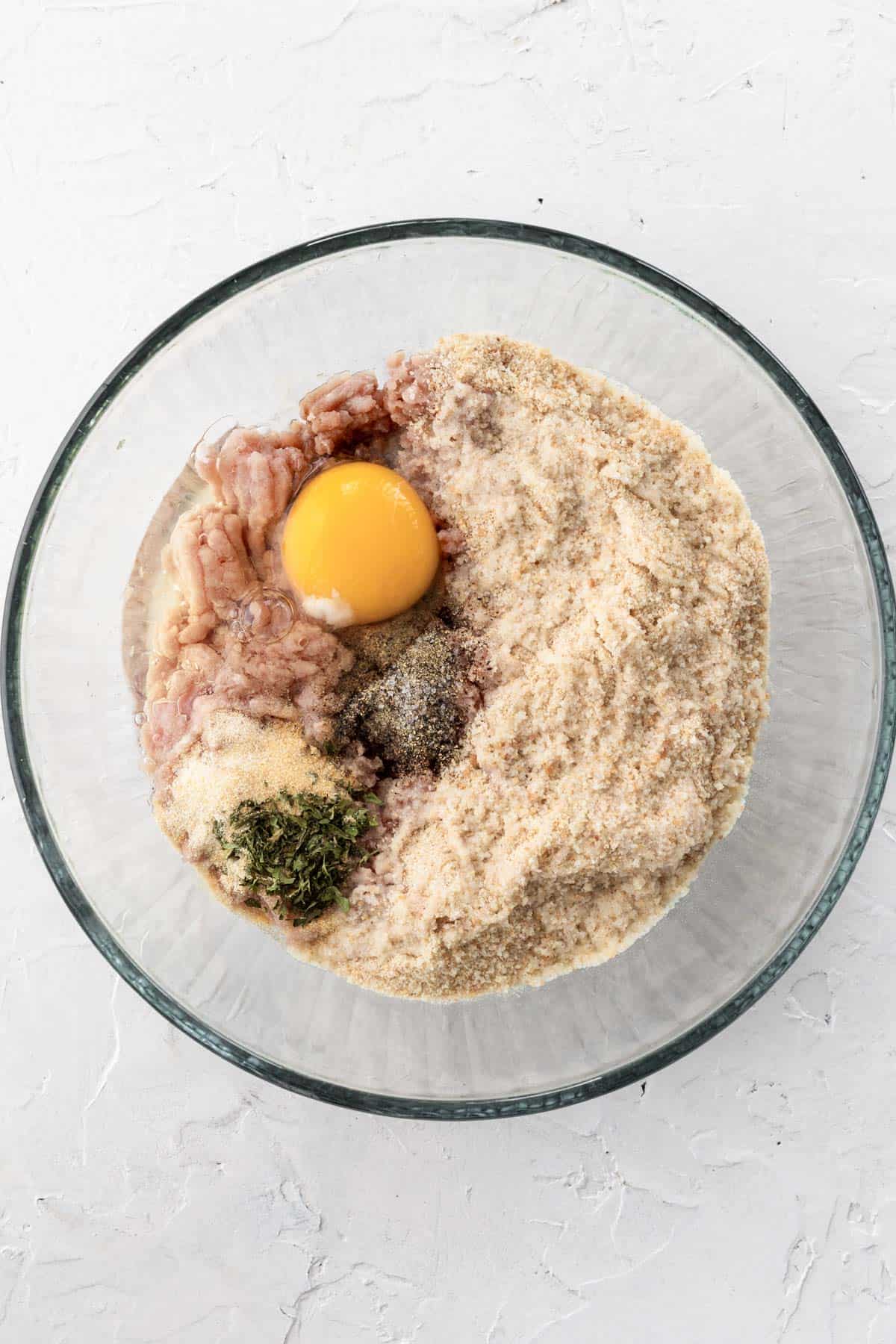 Turkey meatball ingredients in a glass bowl.