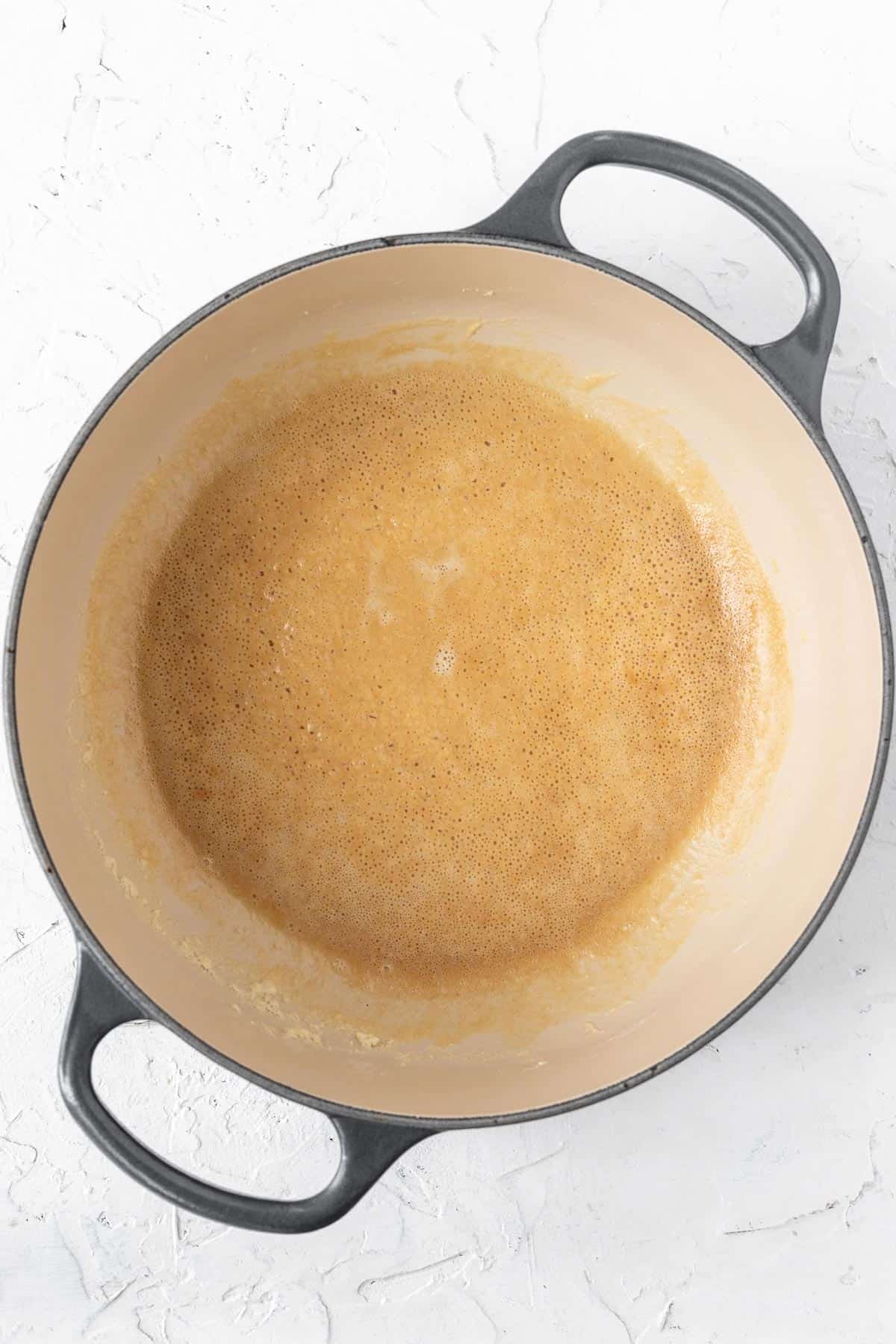 Golden, bubbly roux at the bottom of a dutch oven.