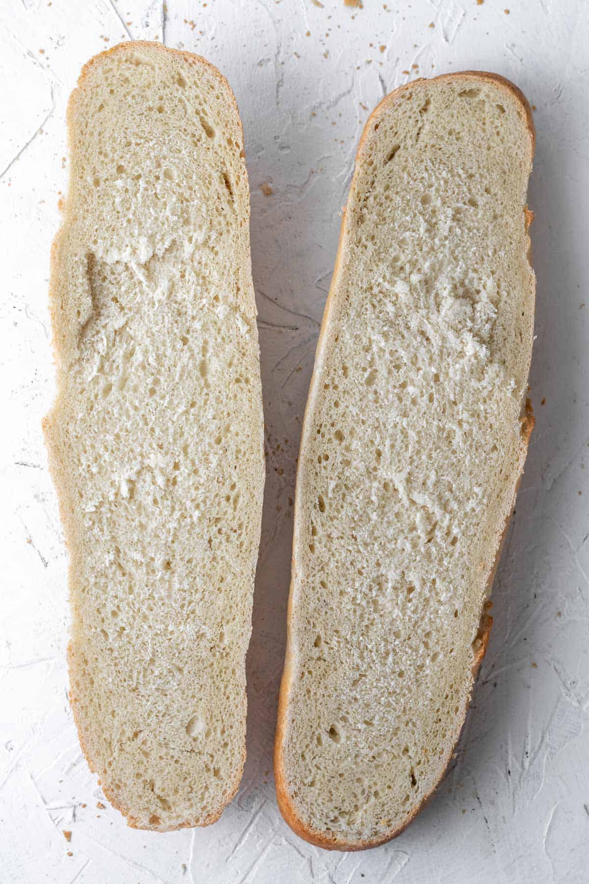 Two halves of french bread that was sliced down the middle lengthwise.