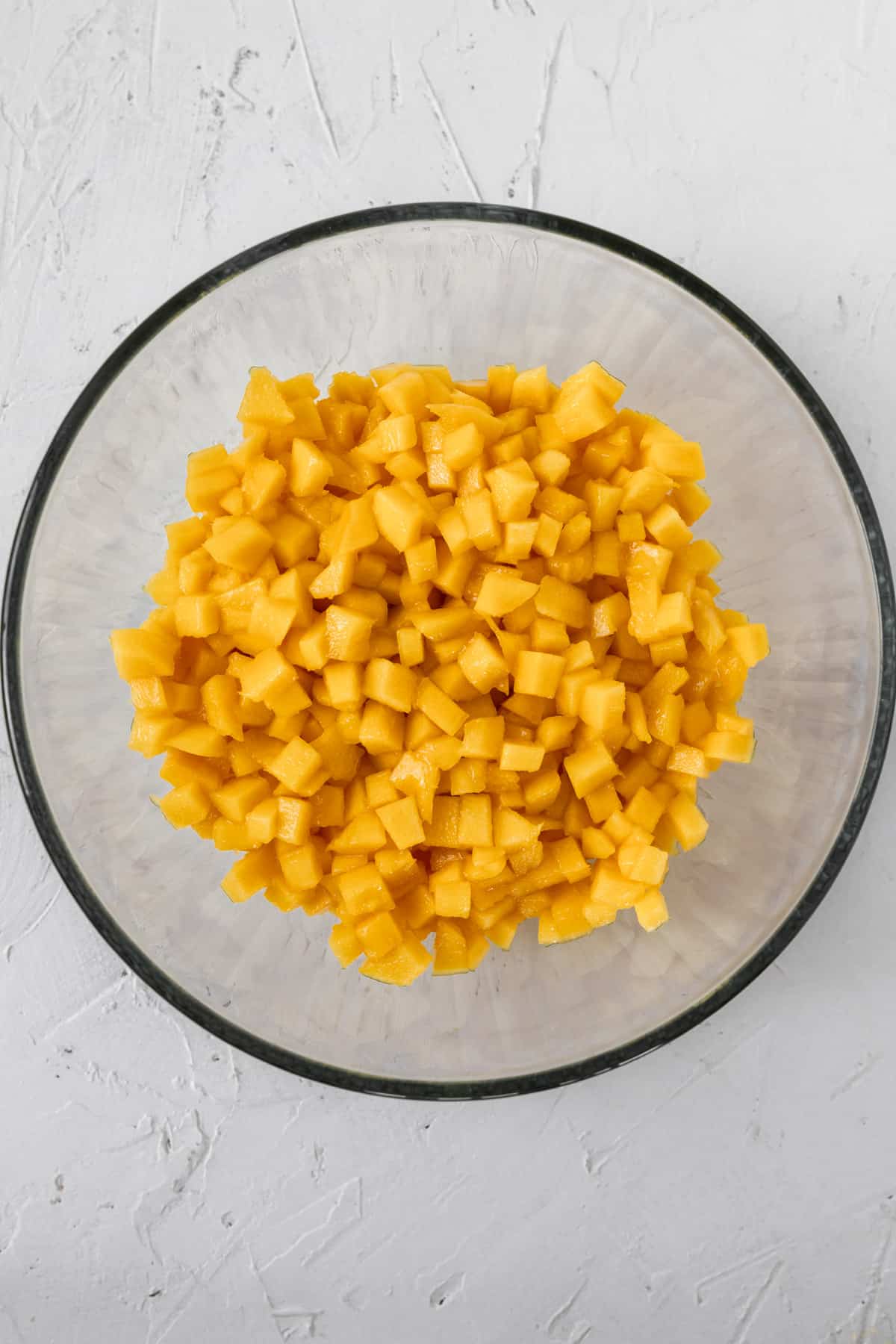 Cubed mango in a glass bowl.