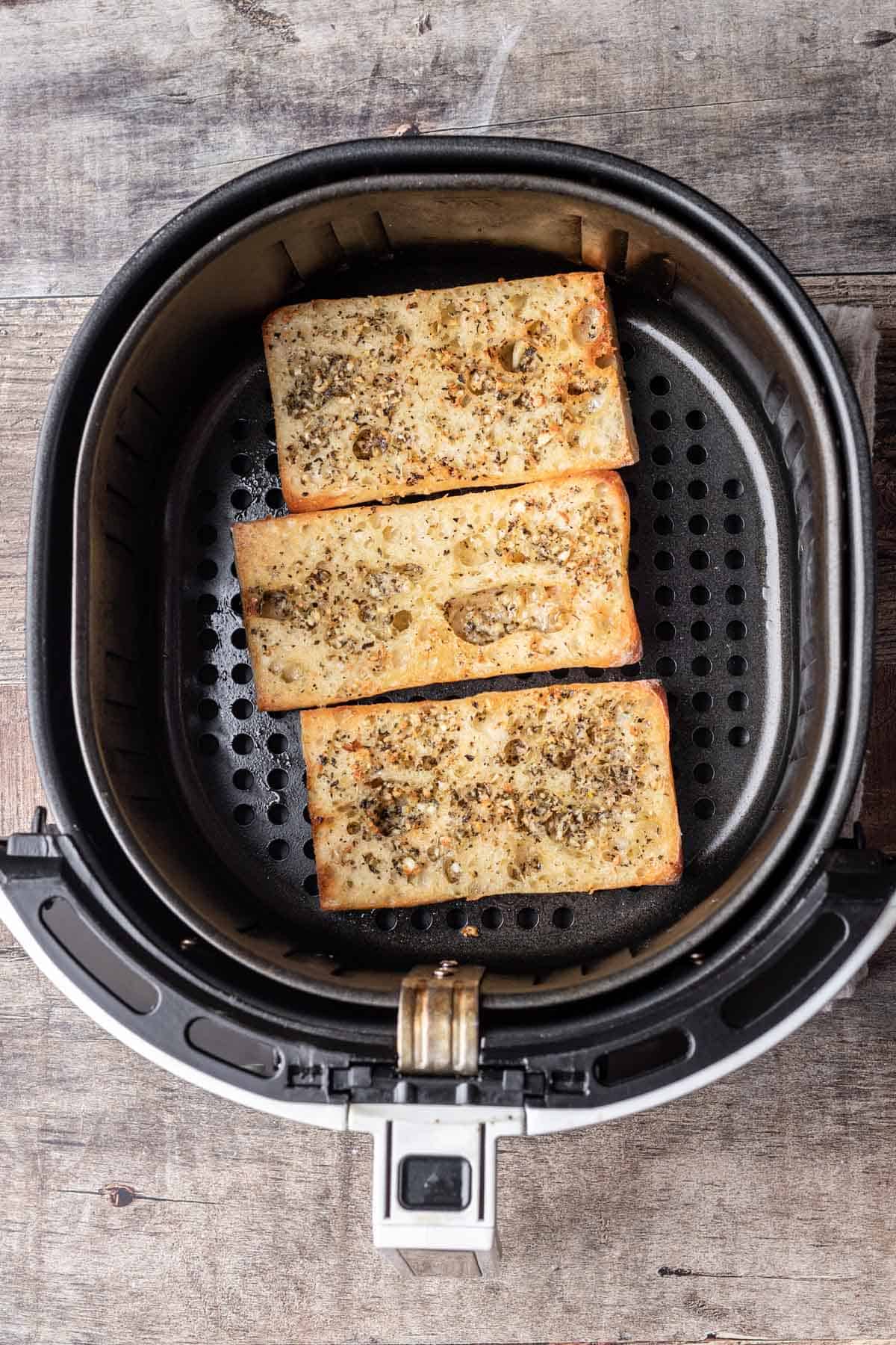 Air fryer garlic bread in an air fryer basket.