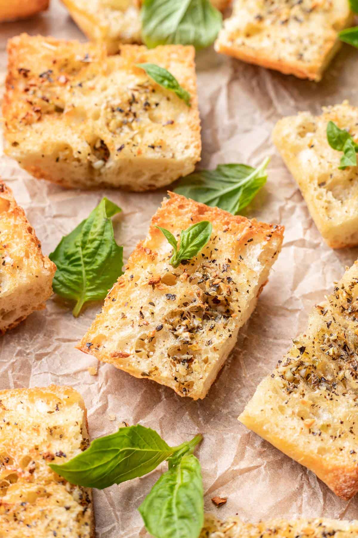 Sliced air fryer garlic bread on crinkled parchment paper.