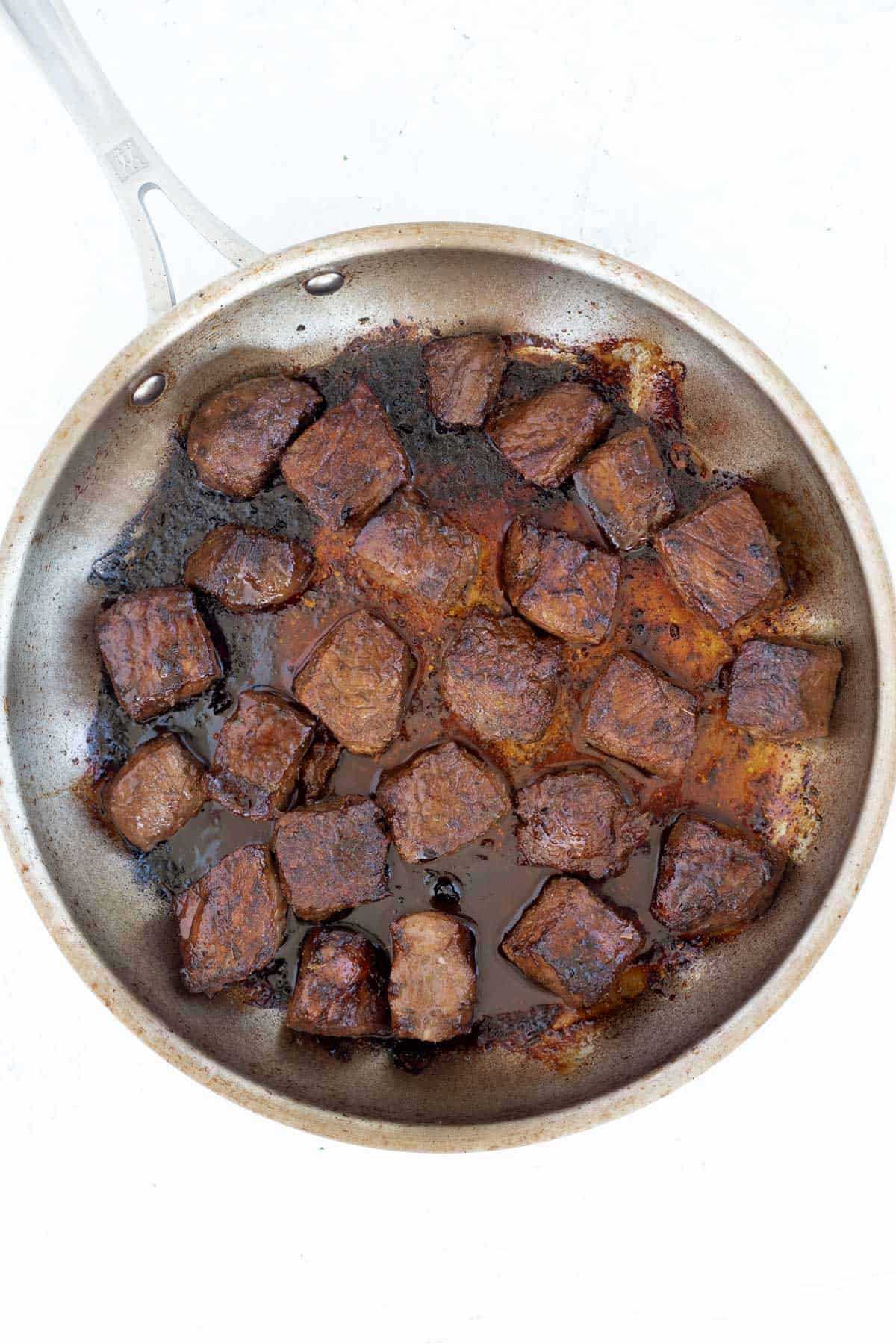 Steak bites cooked crispy in a skillet.