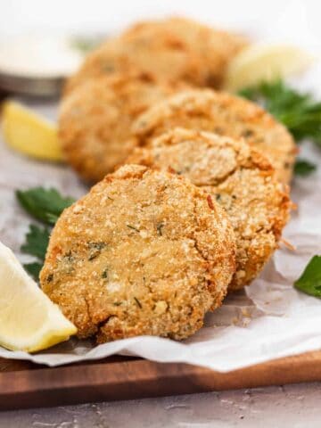 Air fryer chicken patties on a serving platter with lemon slices.