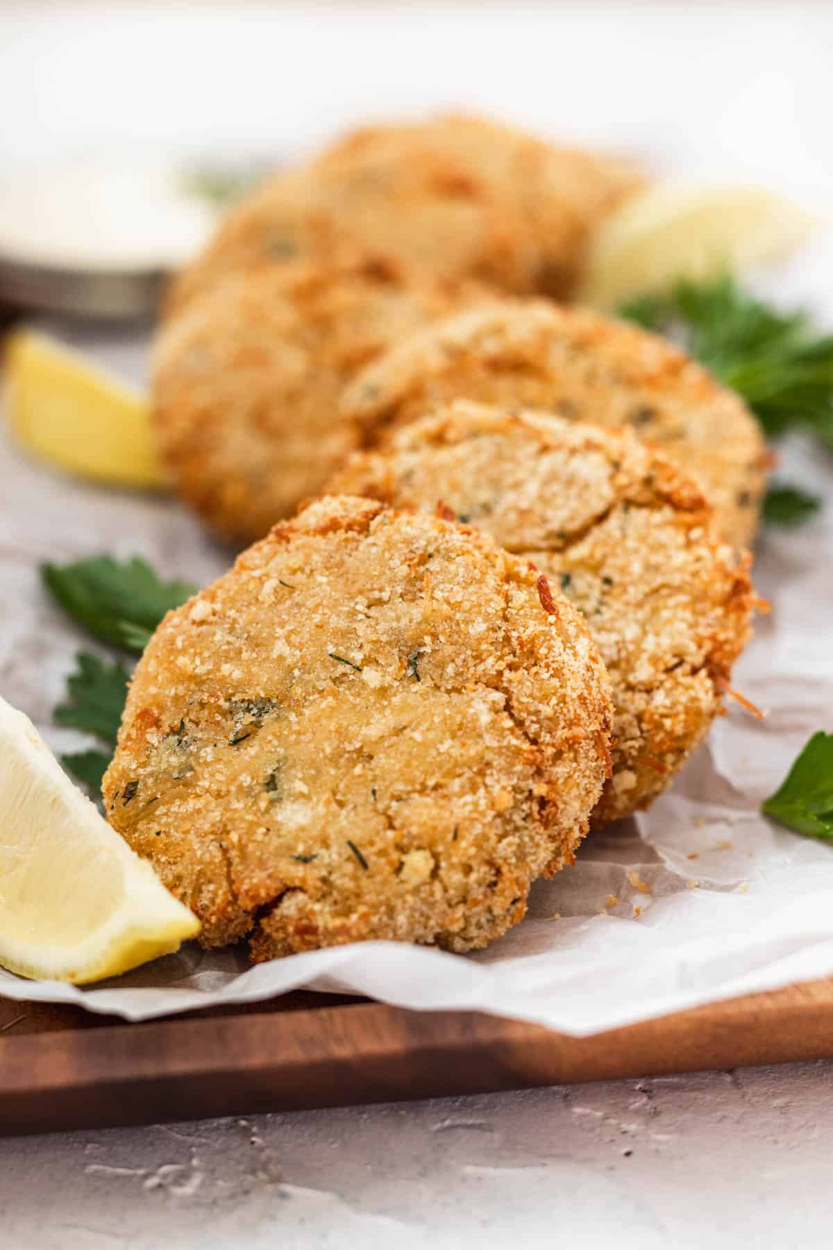 Air fryer chicken patties on a serving platter with lemon slices.