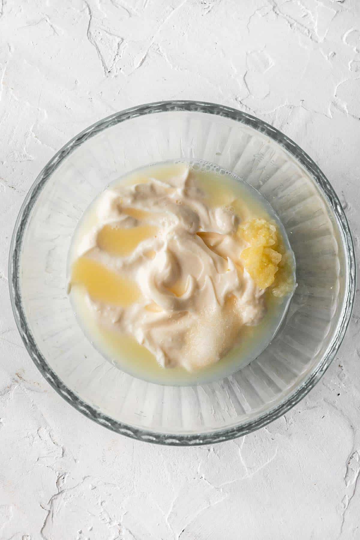 Garlic aioli in a glass mixing bowl.