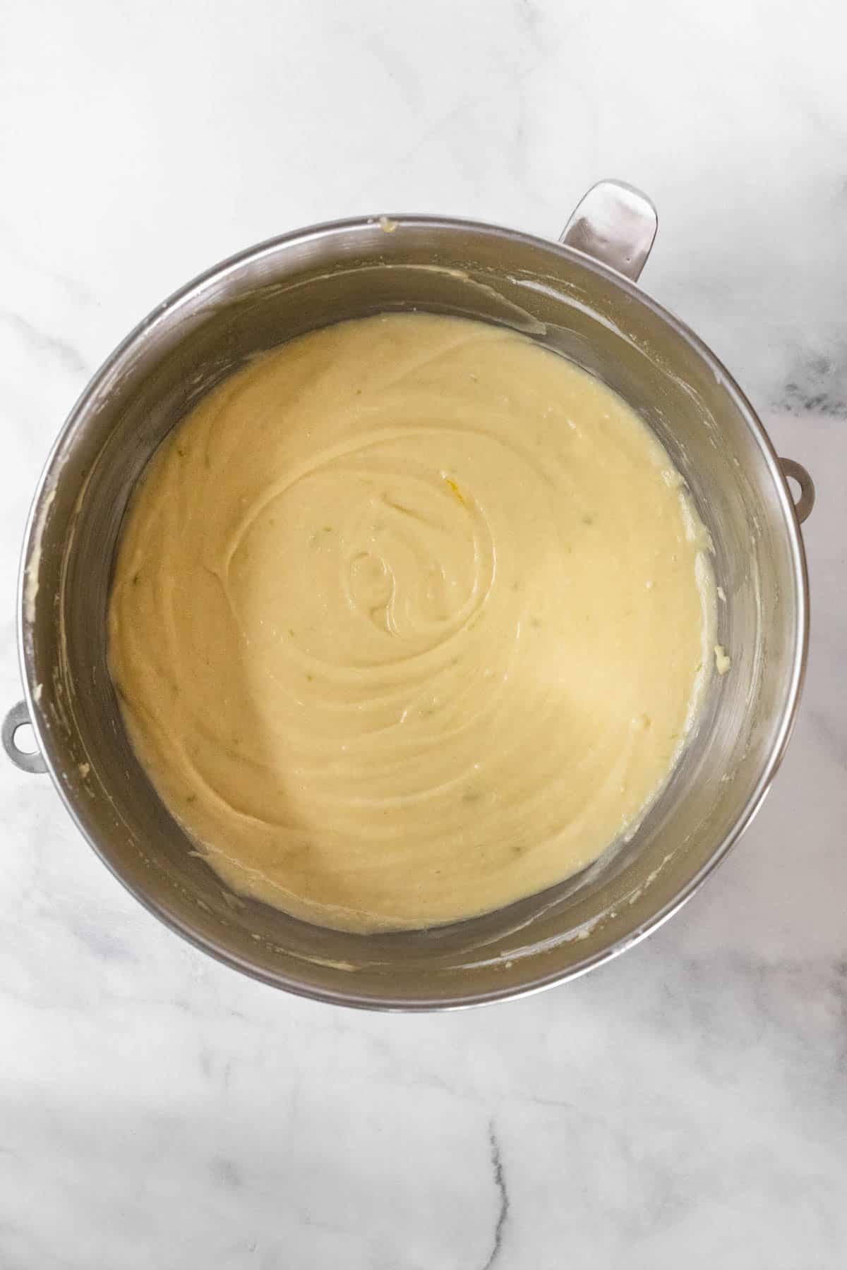 Wet and dry ingredients combined in a metal mixing bowl.