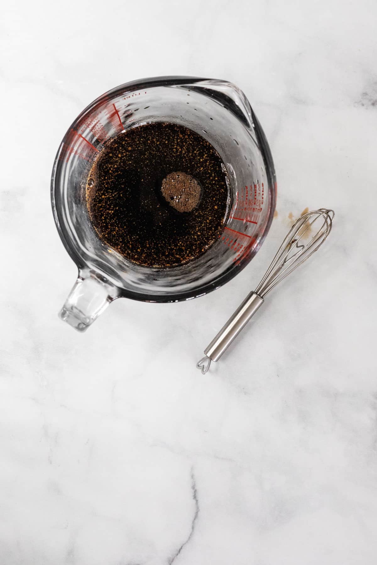 Mixed maple balsamic dressing in a liquid measuring cup.