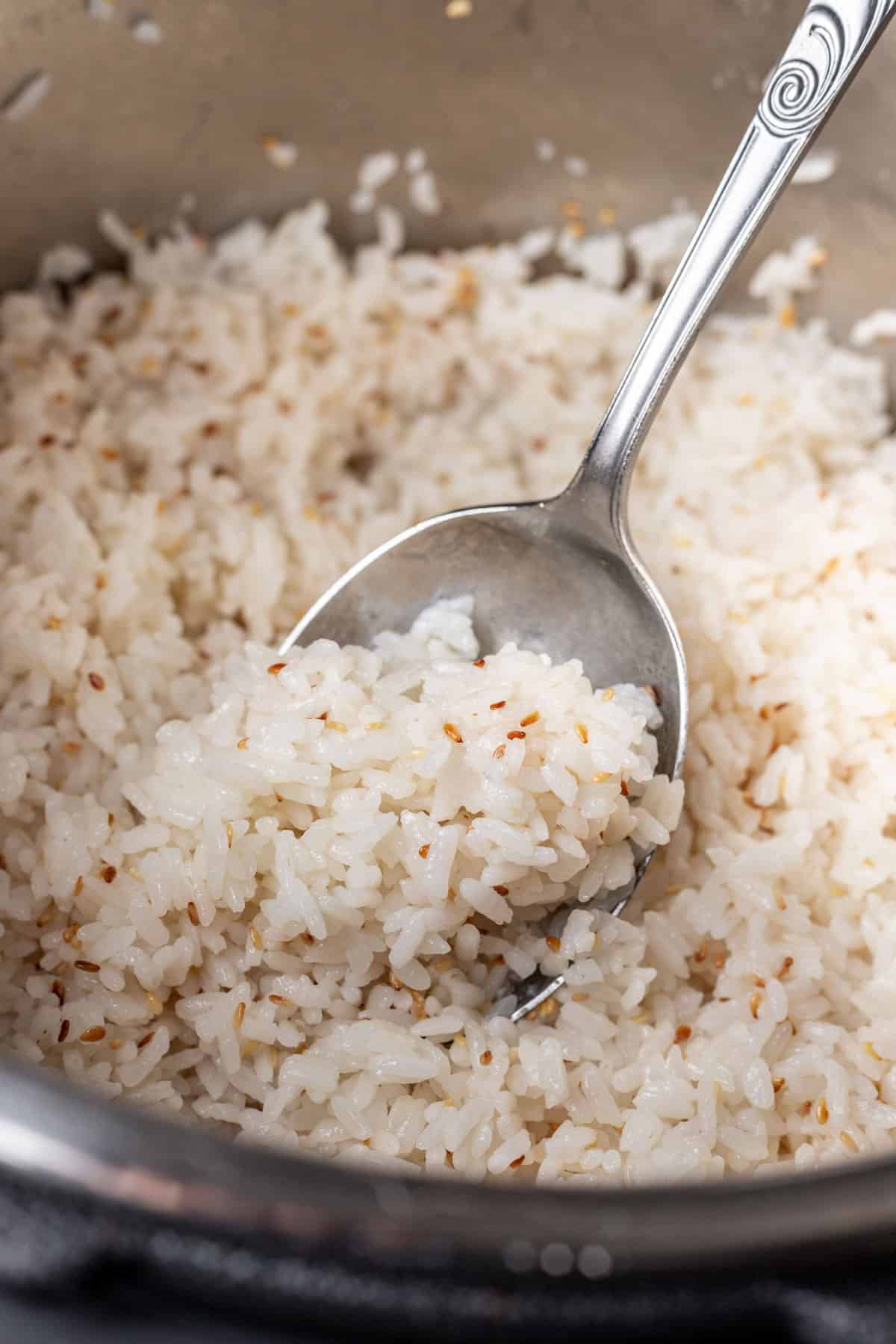A serving spoon scooping sushi rice out of an instant pot.